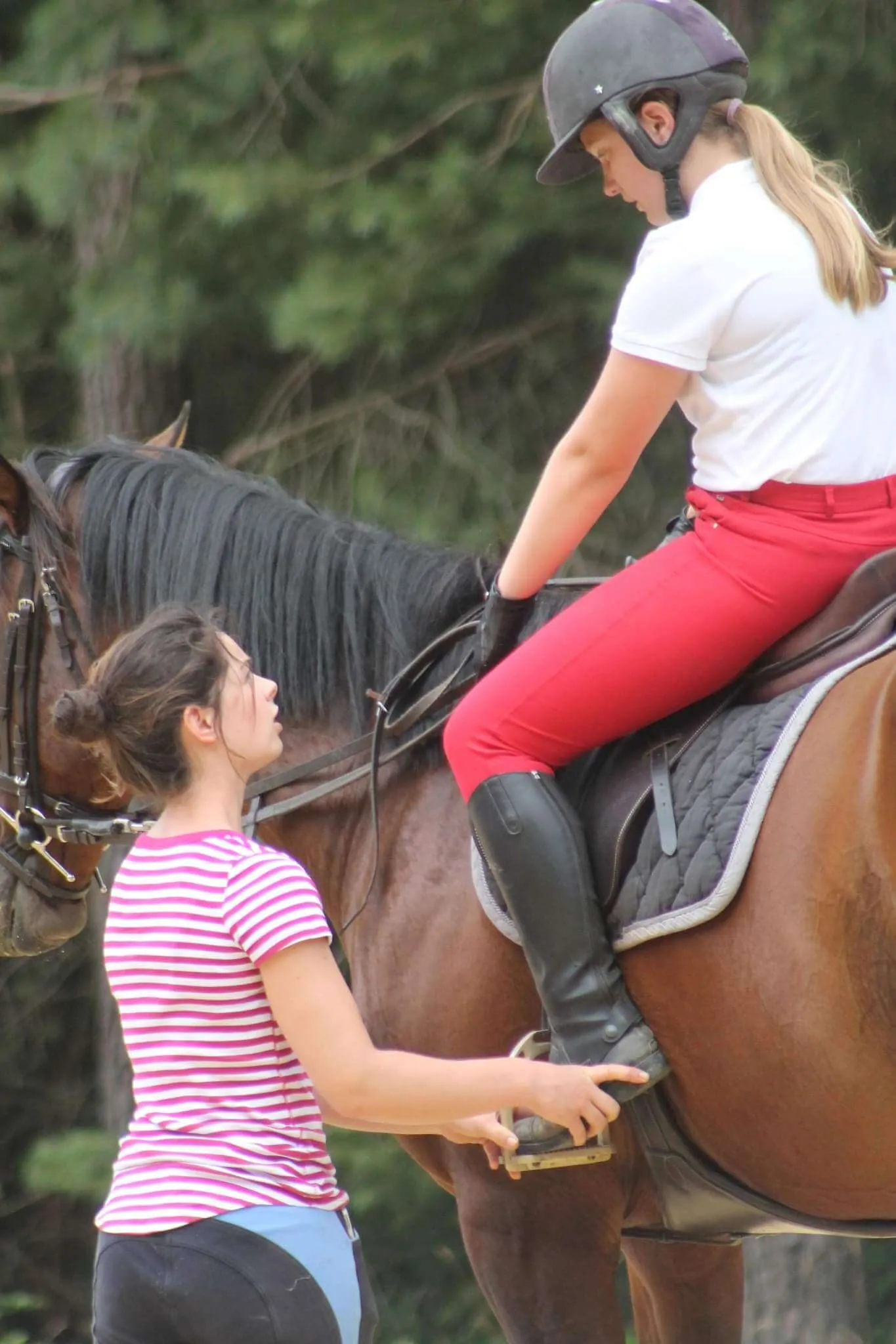 Anne-Laure Miquet corrigeant la position d'une cavalière pendant un cours